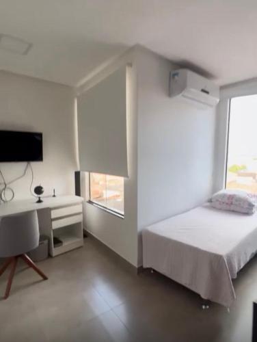 a bedroom with a bed and a desk and a window at Apartamento Completo com 2 Camas in Euclides da Cunha