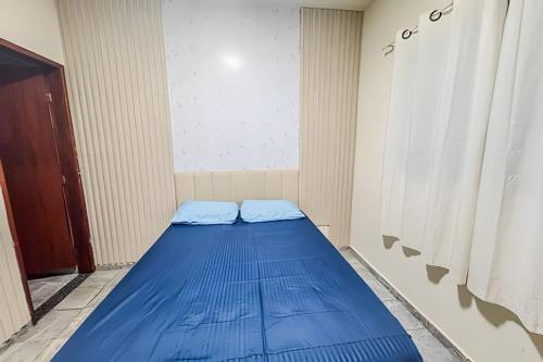 a small room with a blue bed in a room at CDHU Ourinhos in Ourinhos