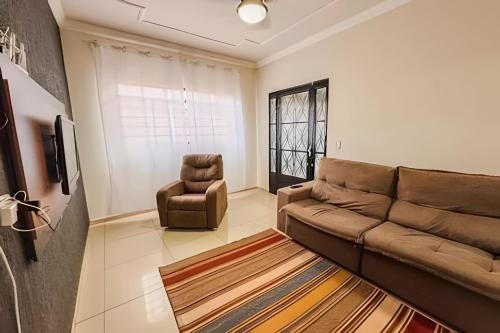 a living room with a couch and a chair at CDHU Ourinhos in Ourinhos