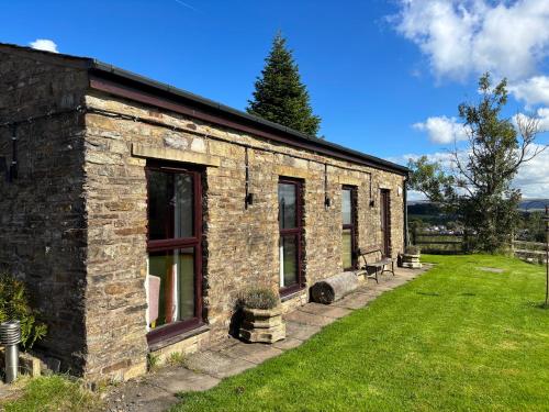 a brick building with windows on a green lawn at Fernhill Hotel in Rochdale