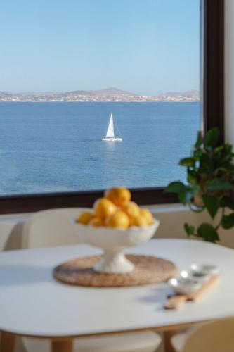 a bowl of fruit on a table with a sailboat in the ocean at ZELION VILLA in Stelida