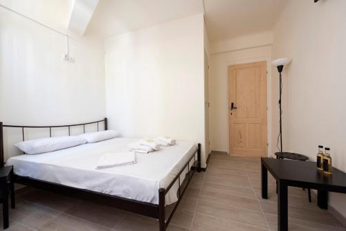 a bedroom with a bed and a table and a door at ATHENS COMMERCIAL in Athens