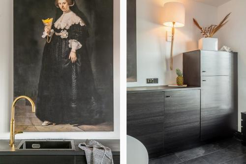 a painting of a woman in a dress next to a kitchen at rembrandtsbeachsuite in Zandvoort