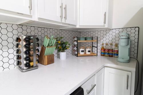 a kitchen counter with white cabinets and wine bottles at Near UF and Shands Cozy Retreat in Gainesville