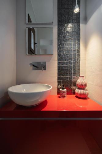 a bathroom with a large white sink on a red counter at ZELION VILLA in Stelida