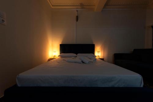 a bedroom with a large white bed with two lights at ATHENS COMMERCIAL in Athens