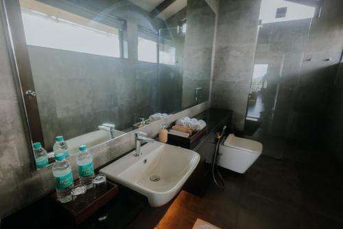 a bathroom with a sink and a mirror and a toilet at Vee Resort- The Suites of Royals in Mahabaleshwar