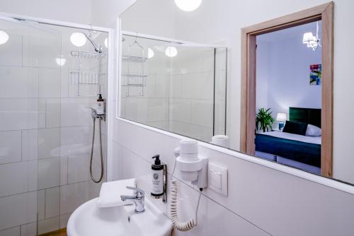 a white bathroom with a sink and a mirror at Elisabeth Old Town in Bratislava