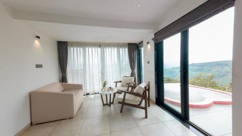 a living room with a view of a pool at Vee Resort- The Suites of Royals in Mahabaleshwar