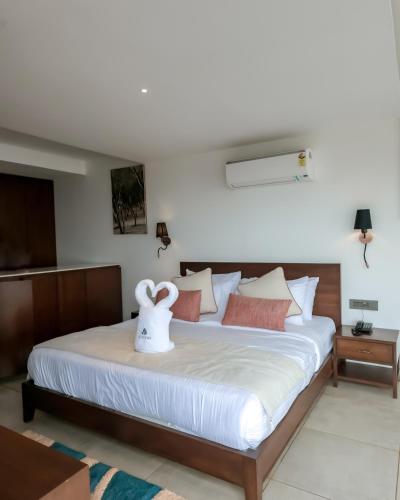 a bedroom with a large bed with white sheets at Vee Resort- The Suites of Royals in Mahabaleshwar