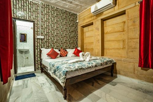 a bedroom with a bed with red and white pillows at Peace & Joy in Jaisalmer