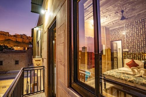 a balcony with a window with a bed on it at Peace & Joy in Jaisalmer