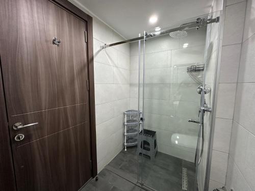 a bathroom with a shower and a glass door at Business class studio with the Mountain View 115А in Batumi