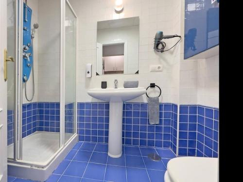 a blue tiled bathroom with a sink and a shower at Cadizz- Estudio Las Flores in El Puerto de Santa María