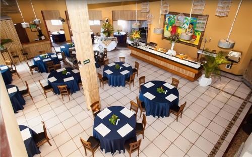Una vista aérea de un restaurante con mesas y sillas. en Galápagos ApartHotel, en Ilhabela