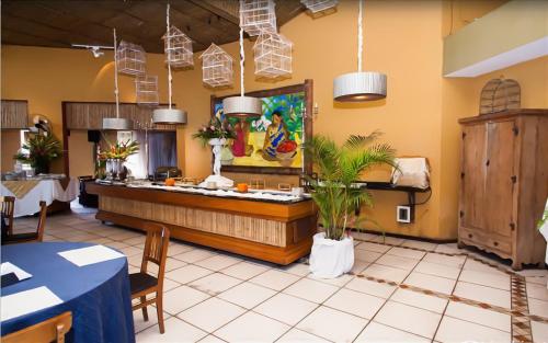 Un restaurante con un mostrador con plantas en una habitación. en Galápagos ApartHotel, en Ilhabela