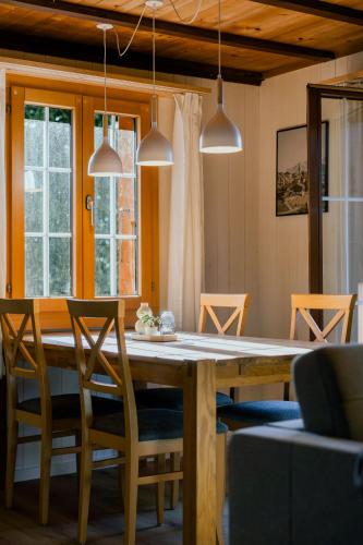 a dining room with a wooden table and chairs at Mountain Loft - Where Design Meets Nature in Axalp