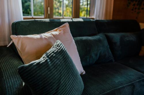 a green couch with a pillow on it at Mountain Loft - Where Design Meets Nature in Axalp