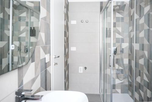 ミラッツォにあるMilazzo Holiday Apartments&Rooms - LiveLoveTravelのガラスのシャワーと洗面台を備えたバスルーム
