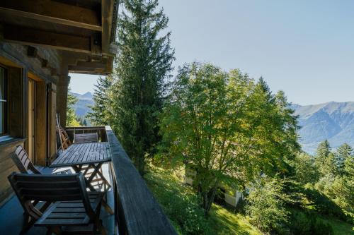 a balcony of a house with two chairs on it at Mountain Loft - Where Design Meets Nature in Axalp