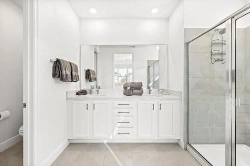 Un baño blanco con lavabo y ducha. en LC517T The Chic Abode at Liberty Bluff, en Kissimmee