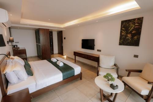 a bedroom with a bed and a desk and a chair at Vee Resort- The Suites of Royals in Mahabaleshwar