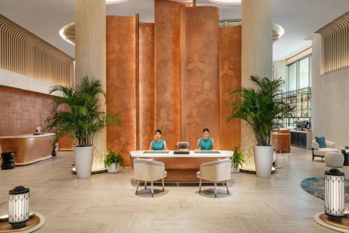 twee vrouwen zitten in een wachtruimte in een lobby bij Pattaya Marriott Resort and Spa in Jomtien Beach