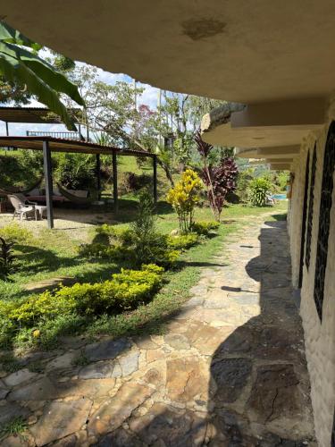 a stone walkway next to a building with a yard at Jaragual EcoHostel in La Vega