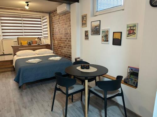 une chambre avec un lit, une table et des chaises dans l'établissement Apartman Nani - Secure and free parking space!, à Sarajevo