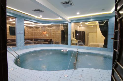 a large swimming pool in a building with at Dorrat Al Nakheel Chalet in Buraydah