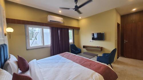 a hotel room with a bed and chairs and a window at Hotel Curl in Jāmb