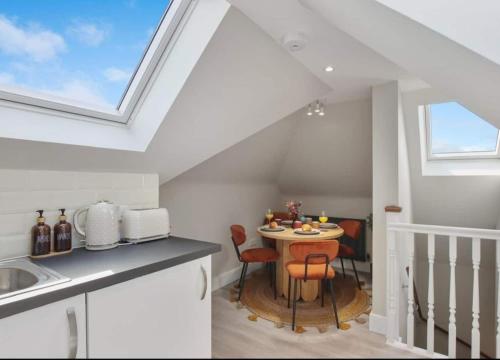 a kitchen with a table and a skylight at Stylish 1BR Apartment Wembley Stadium Sleeps 4 in London
