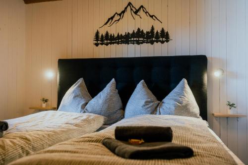 a bedroom with a bed with blue pillows at Mountain Loft - Where Design Meets Nature in Axalp
