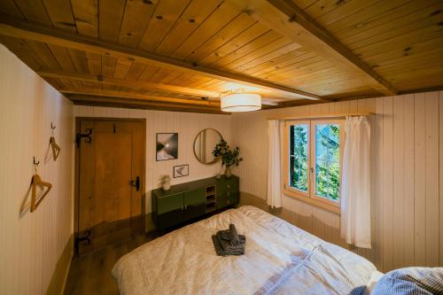 a bedroom with a bed and a window at Mountain Loft - Where Design Meets Nature in Axalp