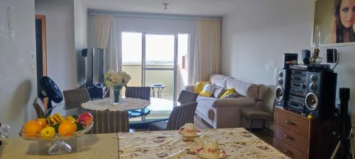 ein Wohnzimmer mit einem Tisch und einer Obstschale in der Unterkunft AP Vista do Parque in Cascavel