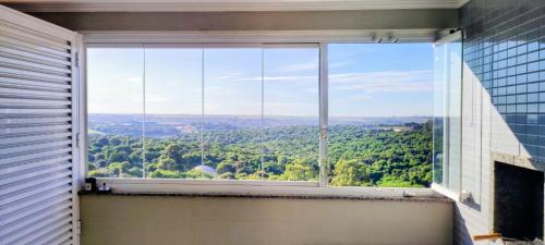 ein großes Fenster in einem Zimmer mit Aussicht in der Unterkunft AP Vista do Parque in Cascavel