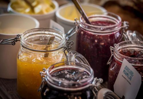 a table with three jars of jam and orange juice at Scandic Torget Bergen in Bergen