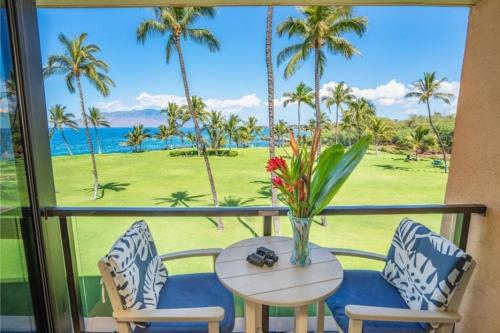 a table and chairs on a balcony with a view of the ocean at KIHEI SURFSIDE, #310 condo in Wailea