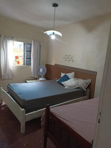 カラグアタトゥーバにあるMassaguaçu beach house with a farmhouse feelの青いシーツのベッドと窓のある寝室