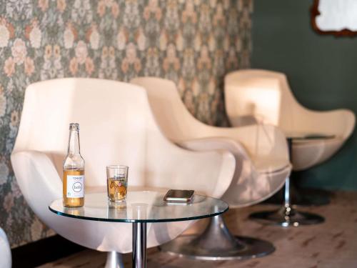 two white chairs and a bottle of beer on a table at greet Chartres Est in Chartres
