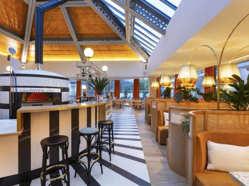 a restaurant with a bar and stools at Le Saint Gervais Hotel & Spa Handwritten Collection in Saint-Gervais-les-Bains