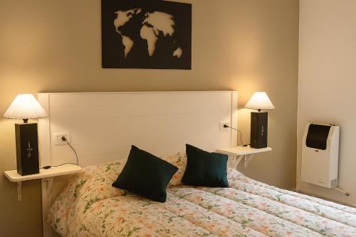 a bedroom with a bed with two lamps and a tv at Tem Kotenkesh Depto Telenken x 2 pax in El Calafate