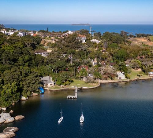 two boats are docked at a dock in the water at Praia Mole Hotel in Florianópolis
