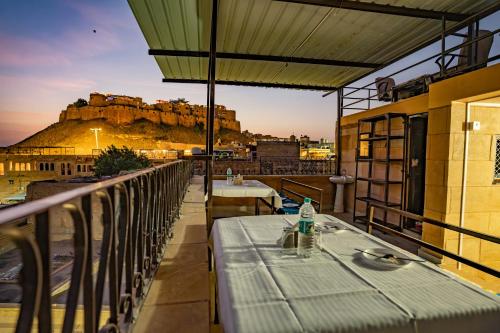 a table on a balcony with a view of a castle at Peace & Joy in Jaisalmer