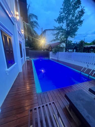 a swimming pool on a deck next to a house at QUEEN'S HOUSE in Luang Prabang