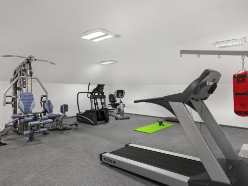 a gym with several treadmills and exercise equipment at Mercure Szekesfehervar Magyar Kiraly in Székesfehérvár