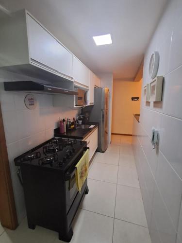 a kitchen with a stove and a refrigerator at Torres Devant COP 30 in Belém
