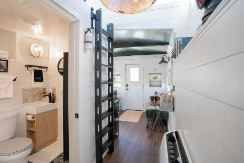 a small bathroom with a toilet and a staircase at Cozy Caboose Retreat | Sleeps 4 | Fire Pit in Fredericktown