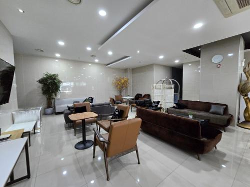 a living room with couches and chairs and tables at Central Plaza Hotel in Seryu-dong