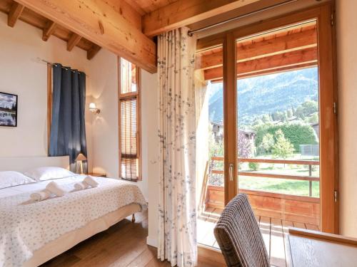 夏蒙尼-勃朗峰Chalet contemporain aux Houches, près des pistes, 6 chambres, WiFi, jardin, grille-pain - FR-1-343-179的一间卧室，里面有一张床和一扇大窗户。